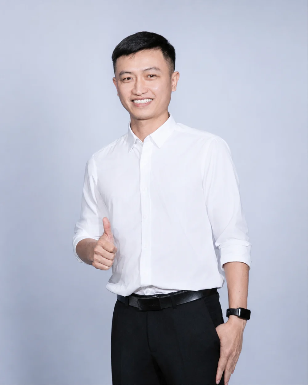 Tat Tran smiling in a white shirt against a soft blue-gray background